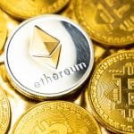Moeda de Ethereum em meio a moedas de Bitcoin.