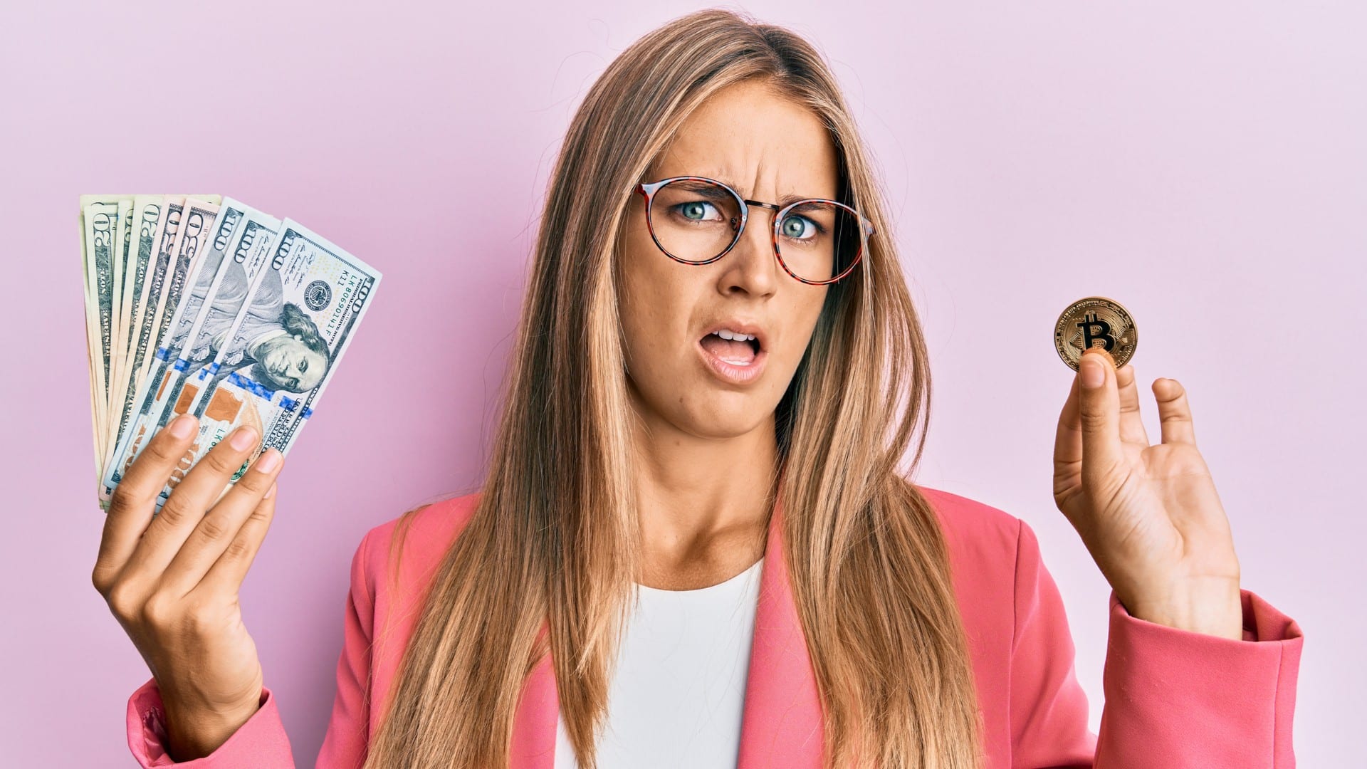 Jovem segurando bitcoin e dólares com rosto em choque