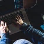 Hacker trabalhando em seu notebook.