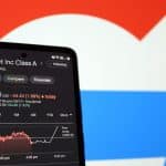 Aplicativo com ações do Google na bolsa em aberto, logo da empresa ao fundo