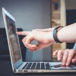 Alunos apontando para tela de computador