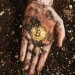 Mão segurando bitcoin - minerador