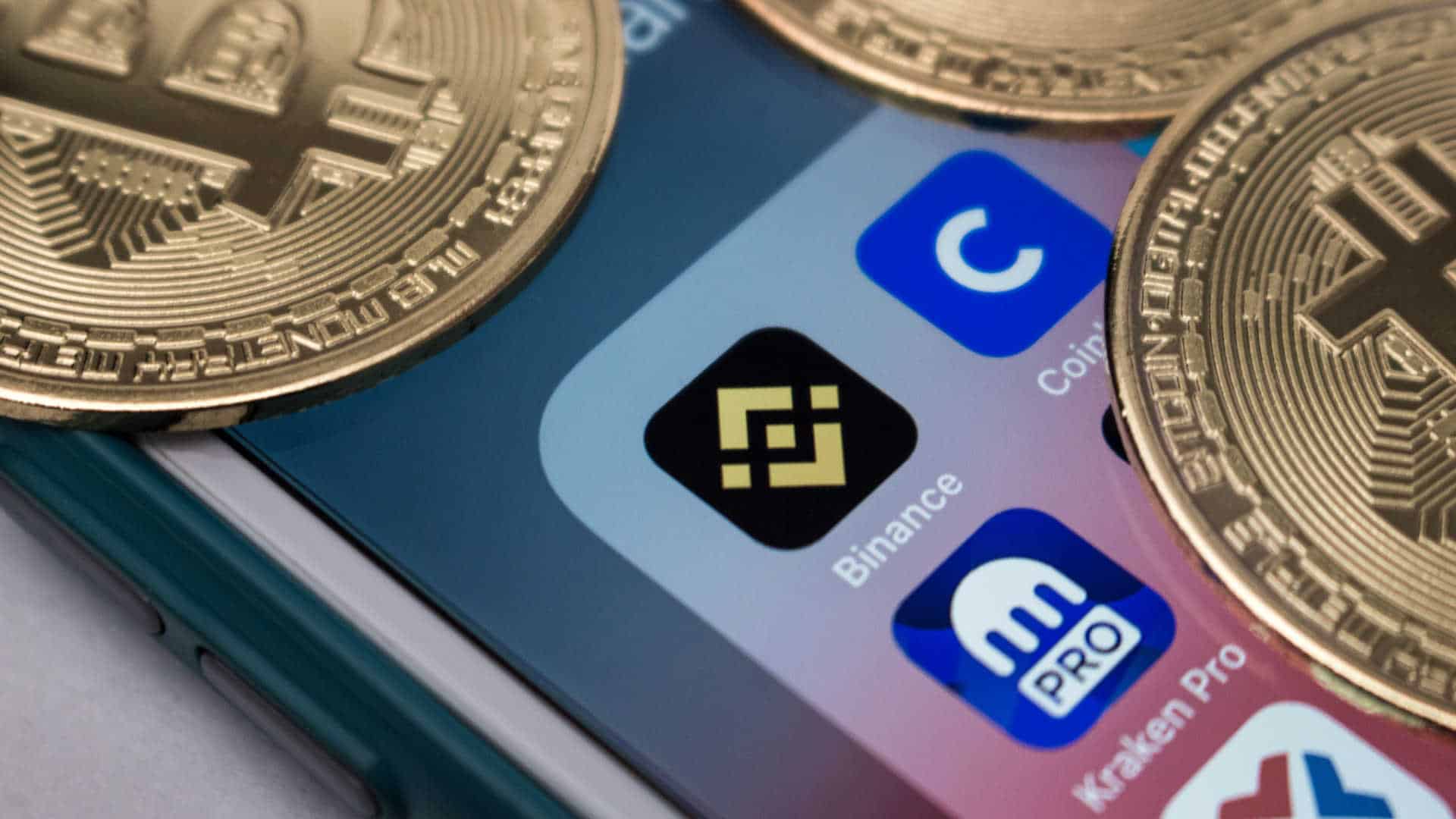 Aplicativos da Binance e Kraken em smartphone.