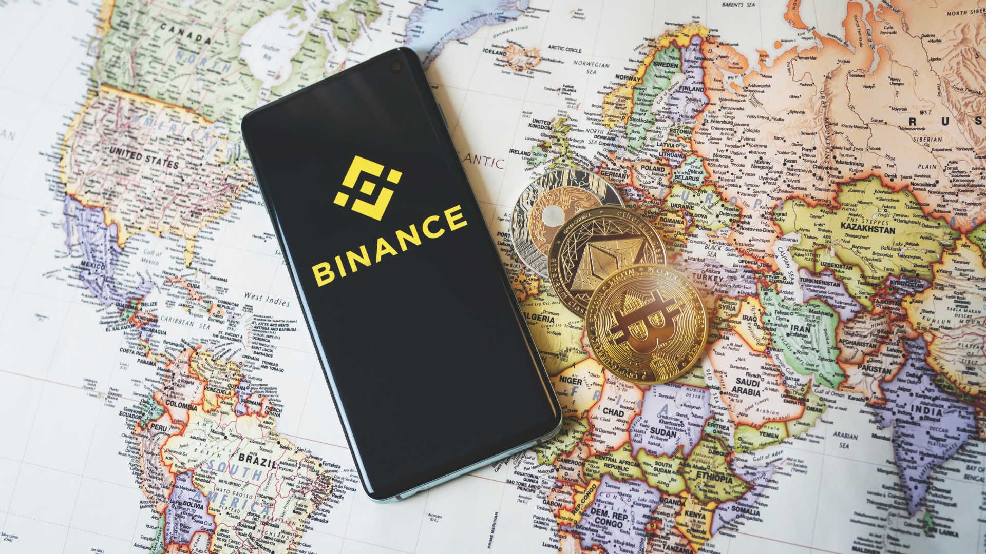 Binance, criptomoedas e mapa do mundo.