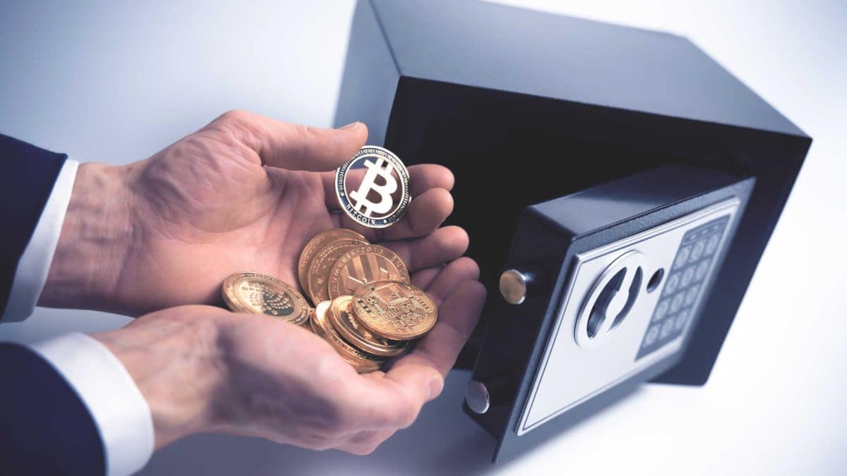 Homem guardando criptomoedas em um cofre.