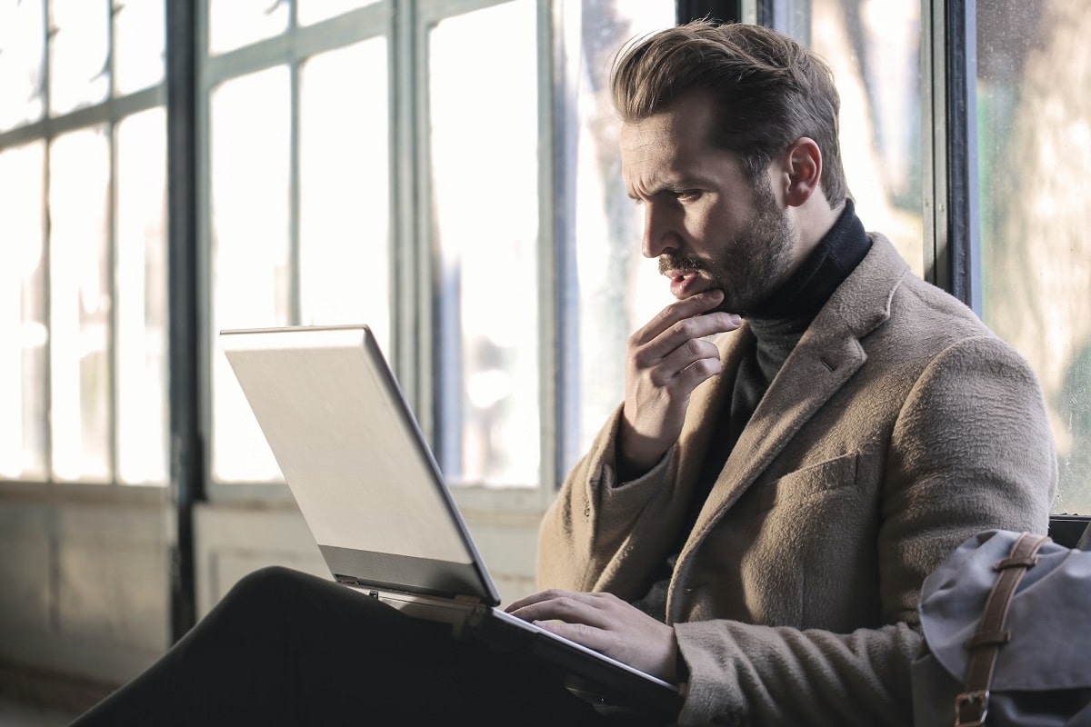 Homem olhando preocupado para tela de notebook