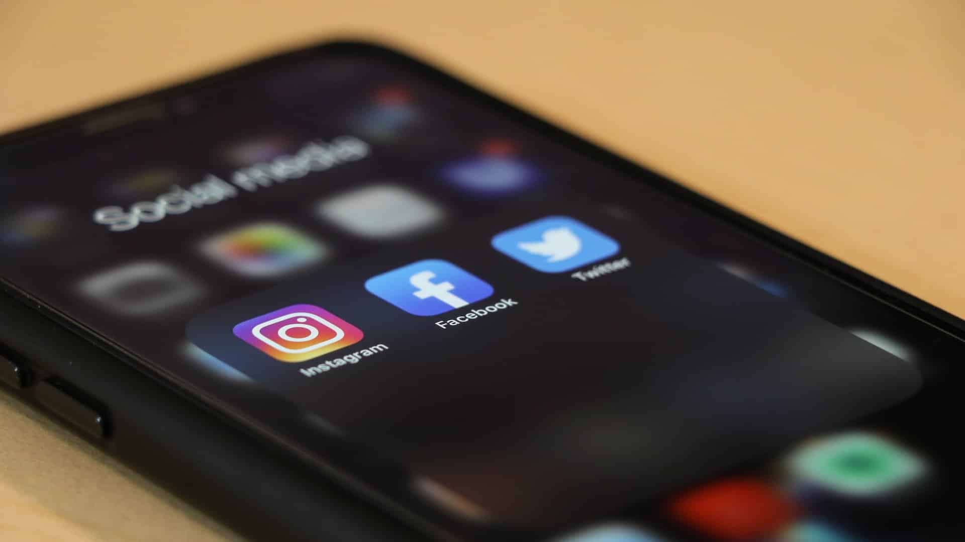 Celular com redes sociais Instagram, Facebook e Twitter em destaque