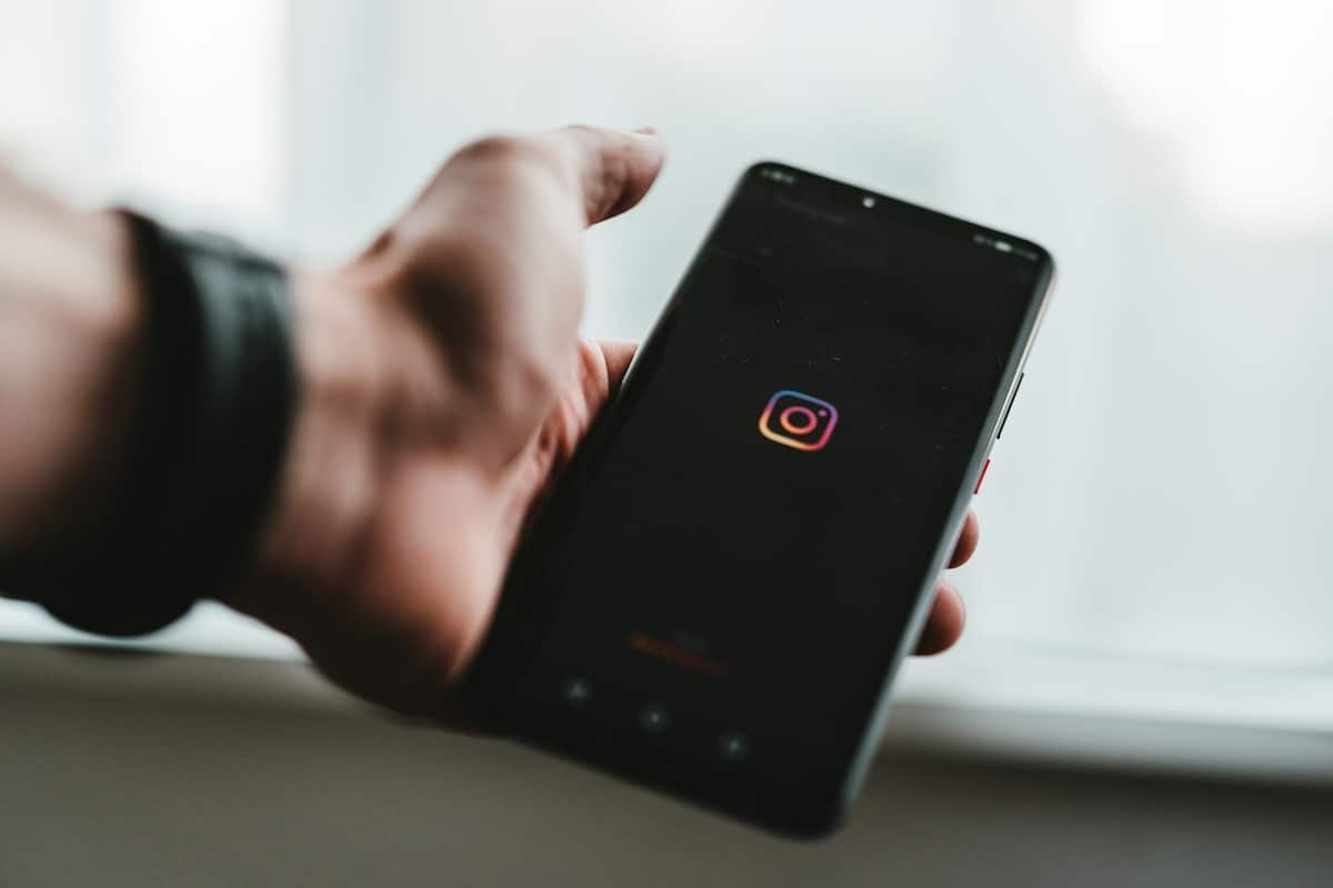 Homem segurando celular com Instagram em destaque
