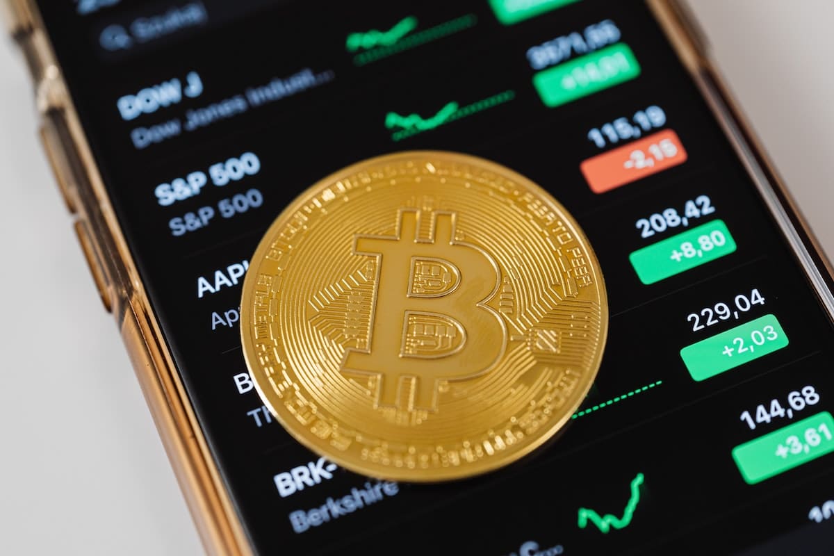 Bitcoin com aplicativo de preços ao fundo