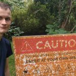 Vitalik Buterin, criador do Ethereum, ao lado de placa de perigo. Fonte: Redes sociais/Reprodução.