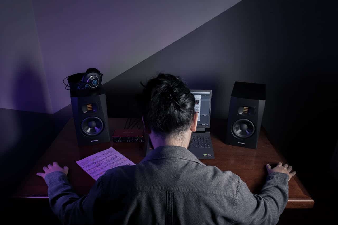 Homem com as mãos na mesa em frente a equipamentos de som hacker e criptomoedas