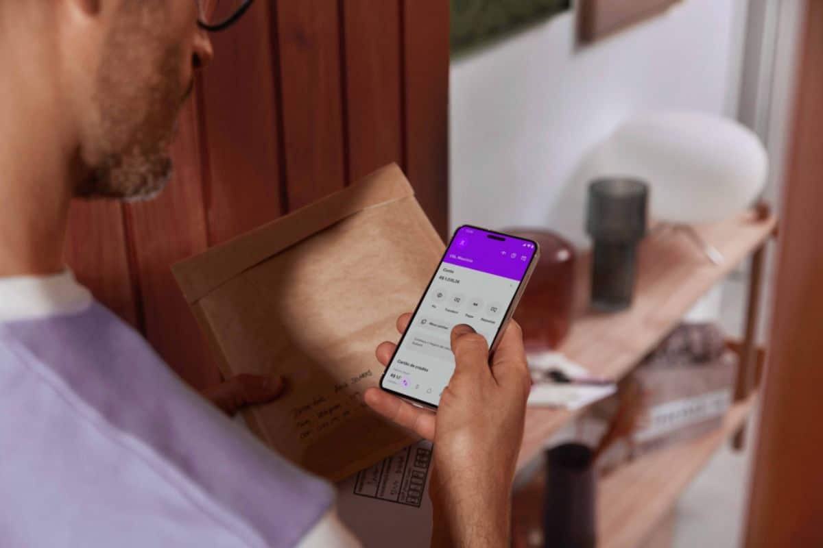 Homem olhando conta do Nubank em aplicativo
