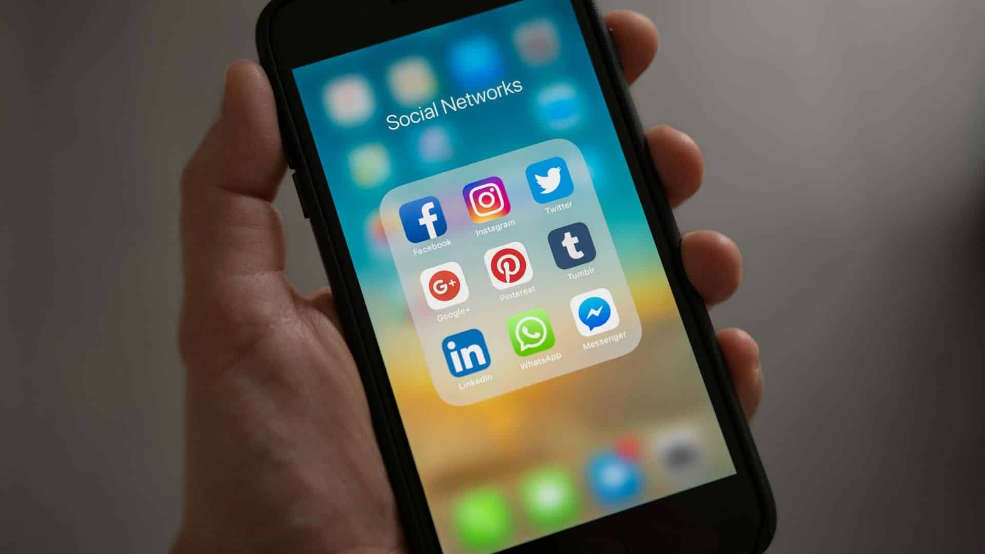 Celular com tela aberta apresentando ícones de redes sociais Facebook Instagram WhatsApp Meta golpes