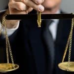 Homem segurando balança da justiça criptomoedas empresa