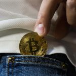 Bitcoin sendo colocado no bolso. Fonte: Worldspectrum/Pexels.