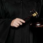 Juiz batendo martelo em decisão corretora de criptomoedas