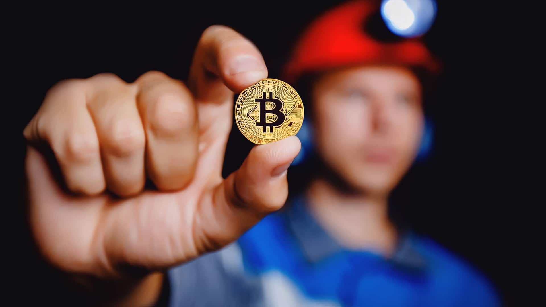 Minerador segurando moeda de bitcoin
