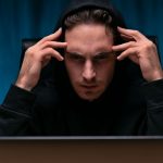 Hacker com mãos na cabeç a bitcoin milhões