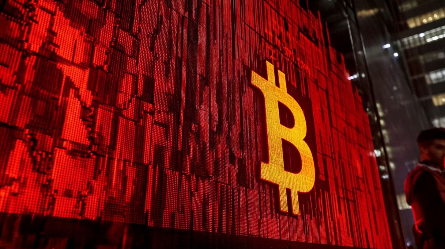 Símbolo do Bitcoin em parede vermelha.