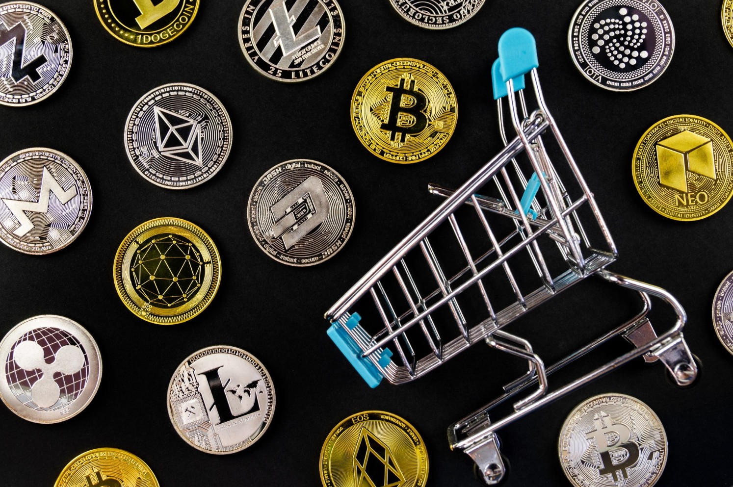 Criptomoedas ao lado de carrinho de compras.