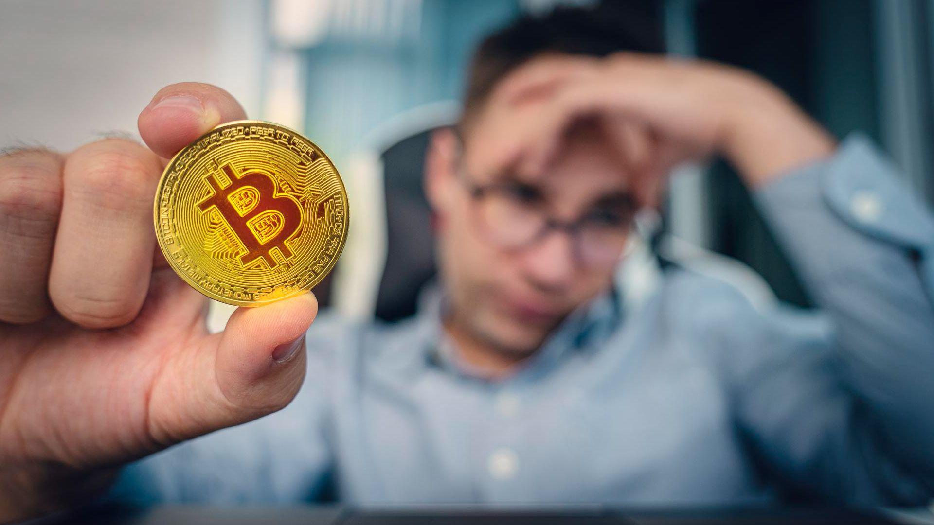 Homem preocupado ao fundo, segurando bitcoin corretora bitcoin criptomoedas banco central regulação