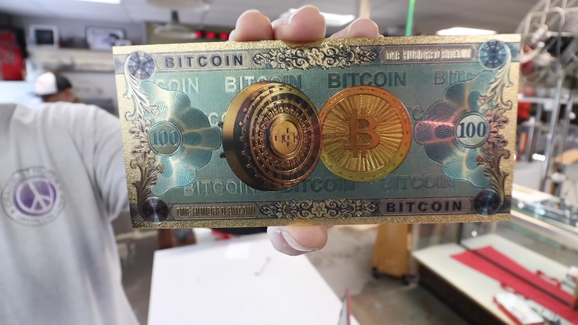 Nota decorativa de “100 bitcoins”, sem algum valor além da arte. Fonte: Craiglist Hunter/YouTube.