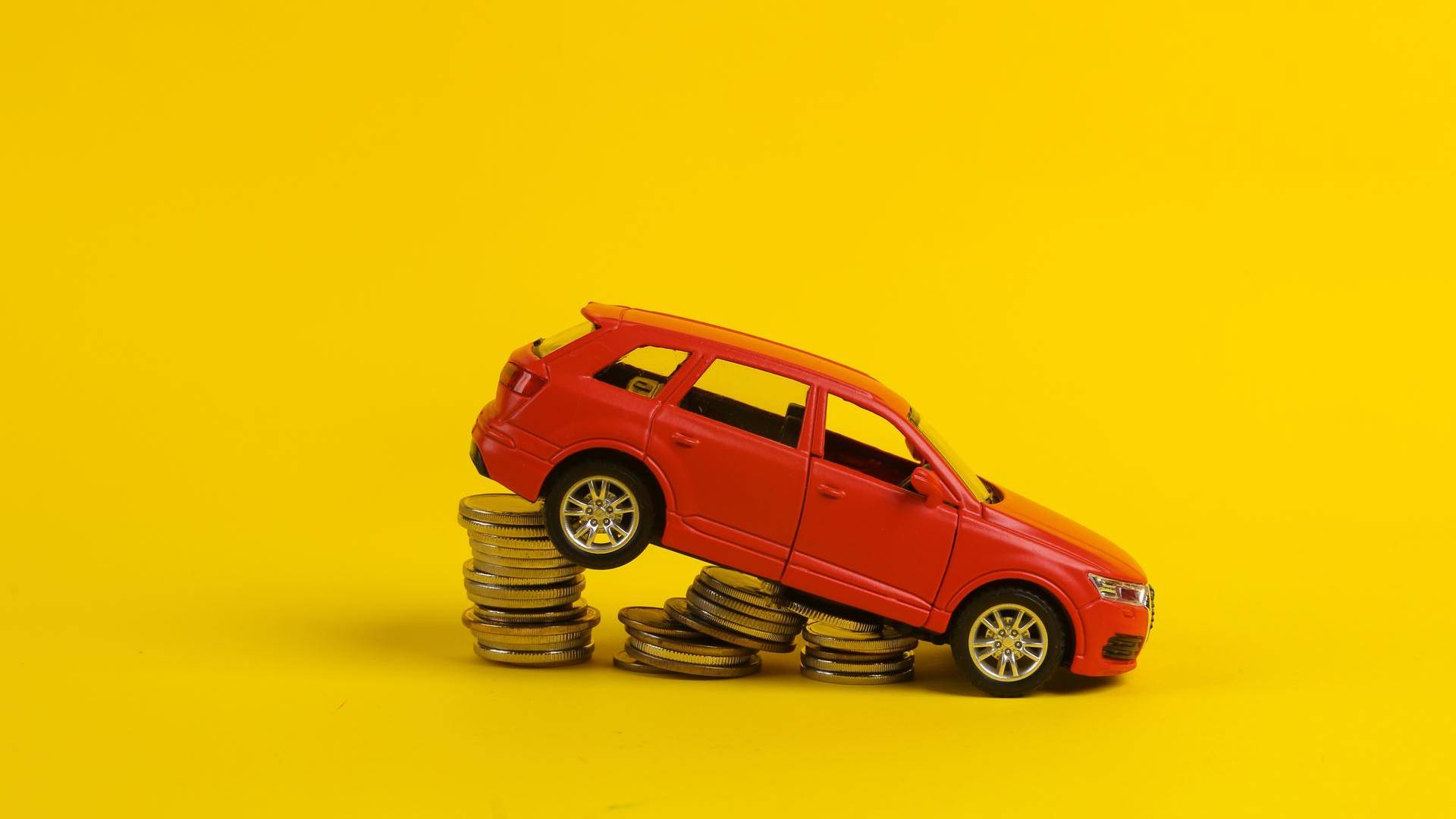 Carro caindo em monte de moedas