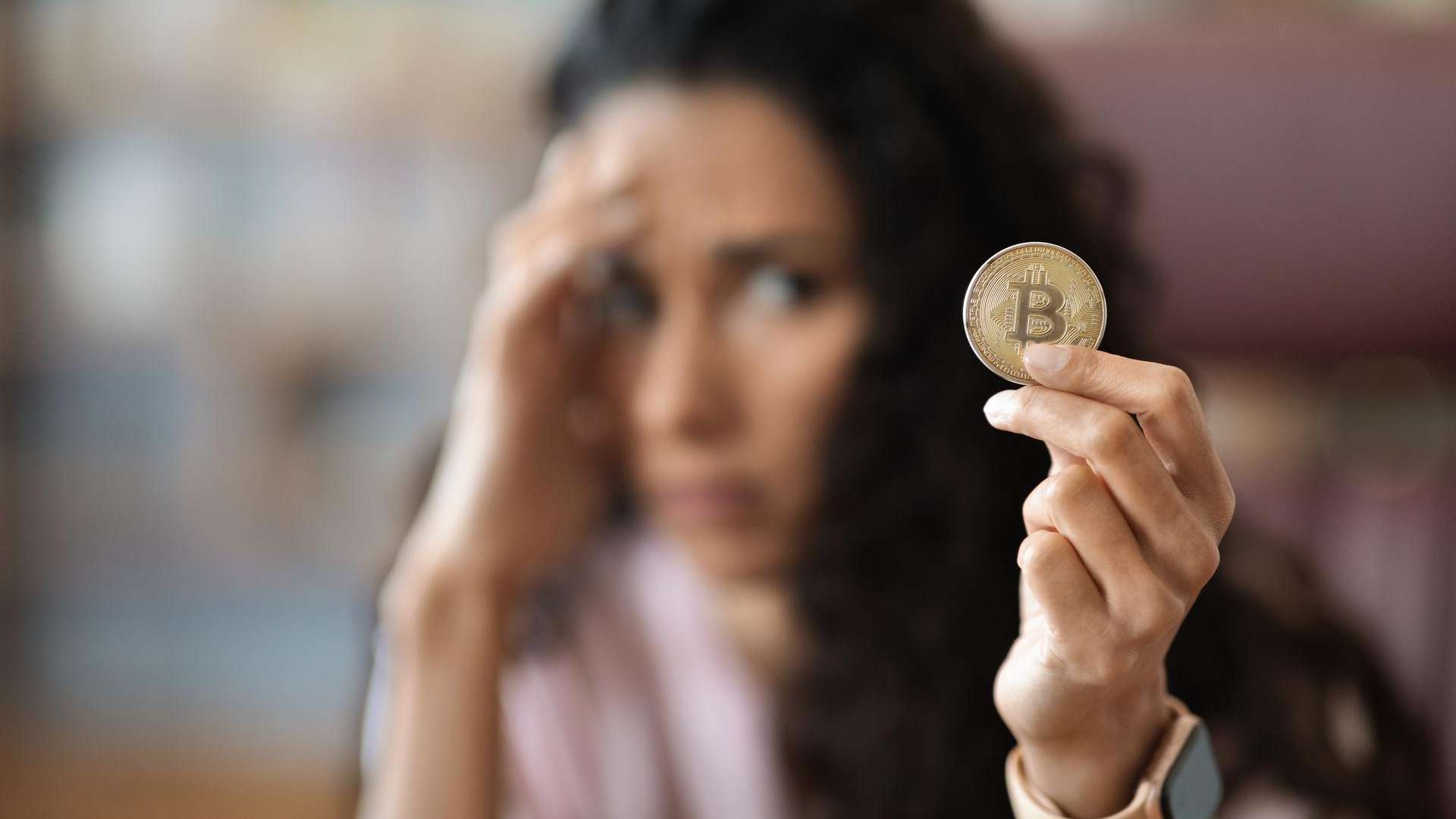 Mulher preocupada com bitcoin na mão corretora criptomoedas