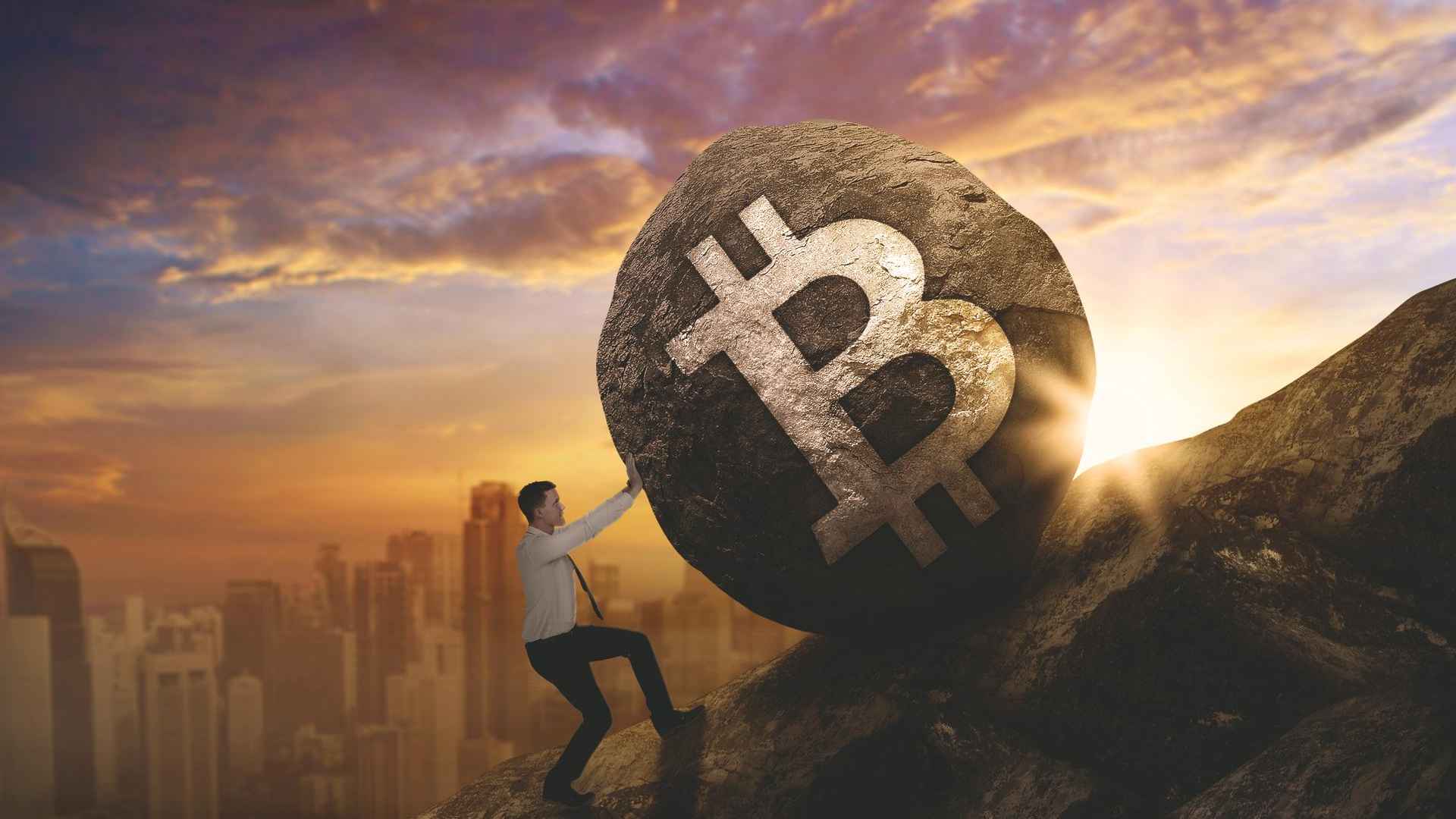 Homem rolando pedra com símbolo do bitcoin em morro bitcoin na contramão do mercado em março