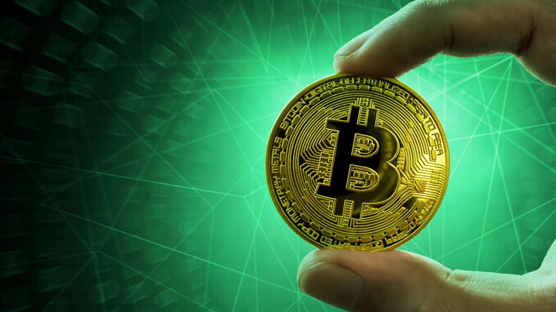 Mão segurando bitcoin, fundo verde Fenynx e Foxbit lançam crédito com garantia em Bitcoin e projetam carteira de R$ 50 milhões em 12 meses