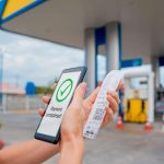 Pessoa pagando em posto de combustível com aplicativo em celular Moradores de El Salvador podem ganhar opção para pagar combustível com USDT