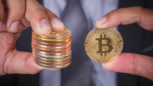 Pessoa segurando moeda com bitcoin