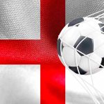 Bandeira da Inglaterra com bola no gol Governo da Inglaterra abre consulta para banir publicidade de apostas no esporte após mostrar preocupações com corretoras de criptomoedas