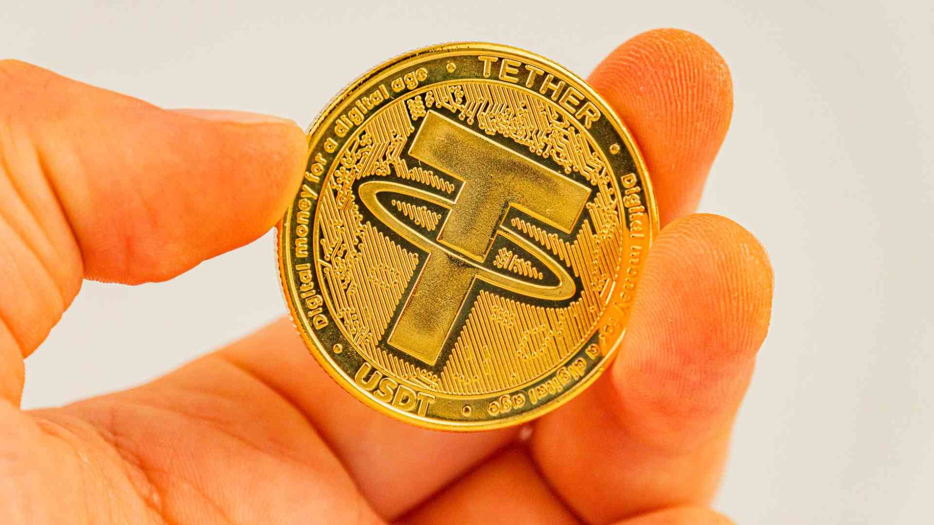 Mão segurando USDT Tether