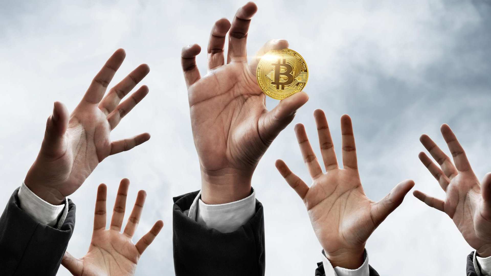 Mão segurando bitcoin com outras tentando pegar a moeda digital Corretoras de criptomoedas devem revelar dados de investidores, diz lei aprovada na Bulgária